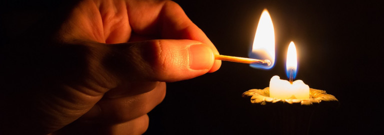 Streichholz zündet Kerze an